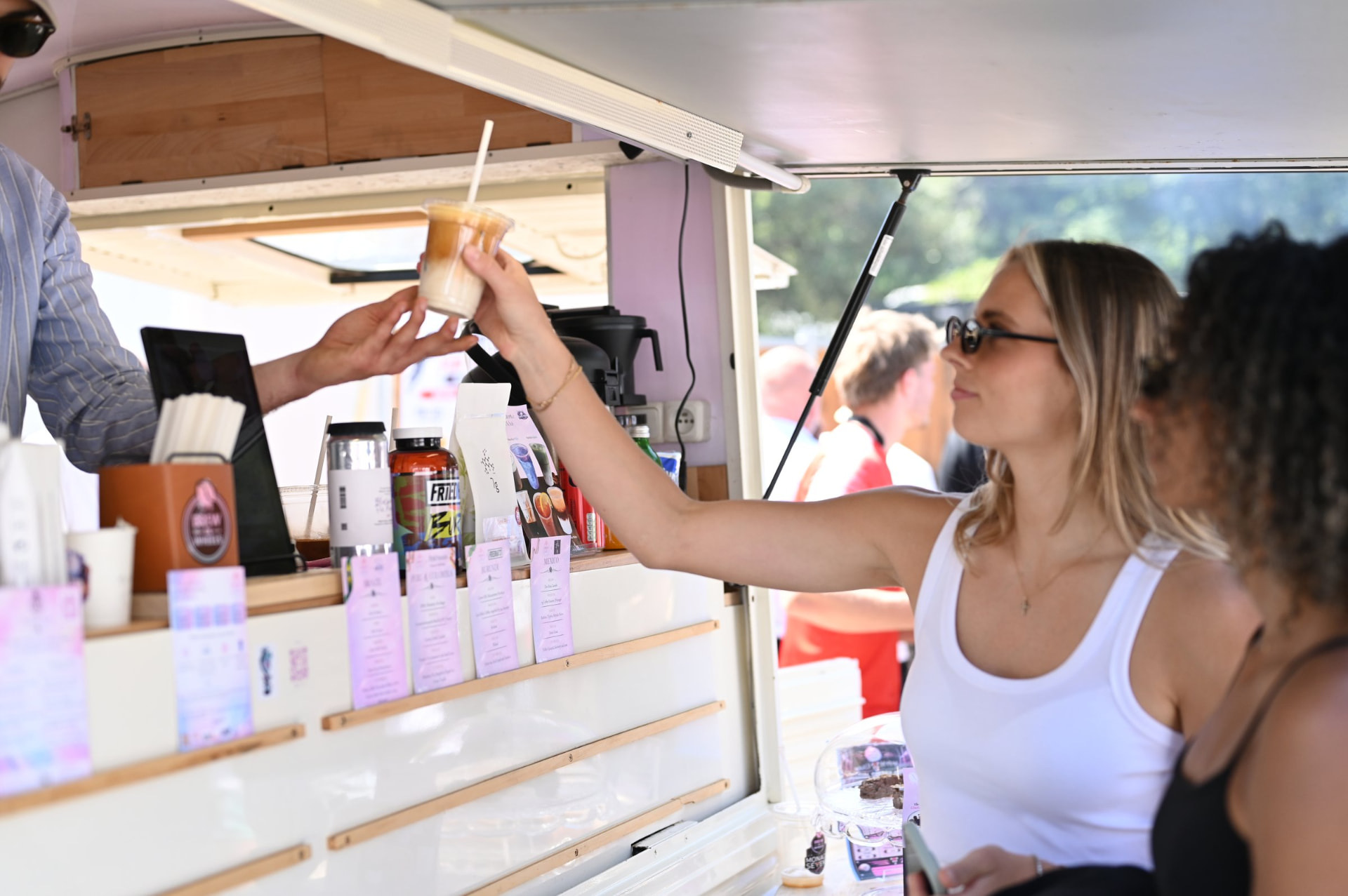 A guest receiving a specialty iced coffee at the Brew on Wheels vintage truck on the Côte d'Azur